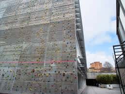 Fachada exterior del polideportivo con muro de escalada