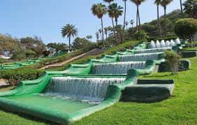 Escalinata de fuentes verdes con palmeras al fondo