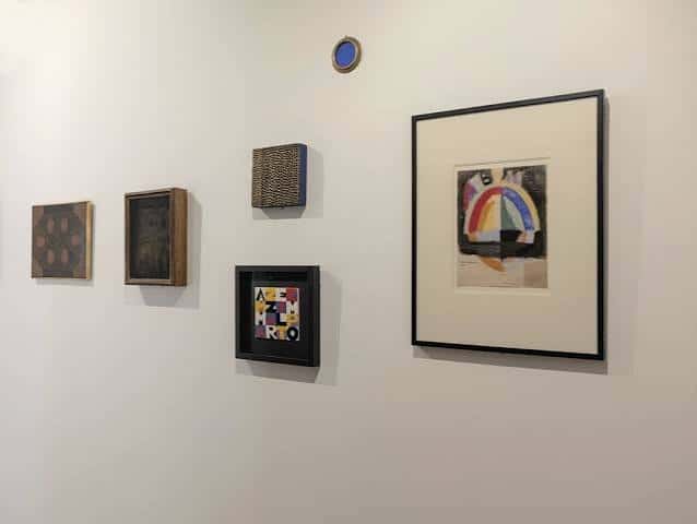 Pared de la galería con obras de arte enmarcadas y detalles decorativos