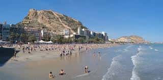 Vista panorámica de la Playa del Postiguet con el monte Benacantil al fondo y edificios costeros