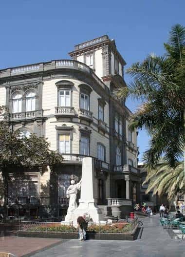 Fachada principal de la biblioteca con detalles arquitectónicos y palmeras