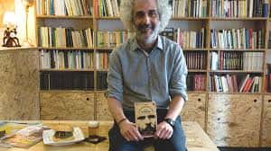 Autor en El Impulso Heroico con su libro y hamburguesa en la mesa