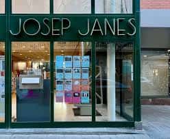 Fachada principal de la Biblioteca Josep Janés con grandes ventanales y letrero verde