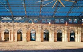 Interior del hall principal con techo de vidrio y arcos decorativos