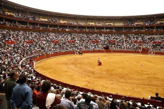 Vista interior de la plaza de toros durante una corrida con público en las gradas