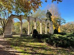 Vista del pórtico de arcos clásicos en el Parque de la Isla con árboles otoñales