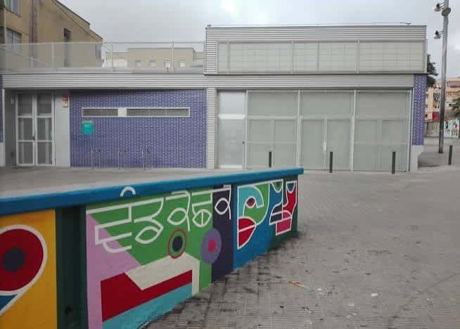 Fachada del centro con muro de contención pintado con arte urbano colorido