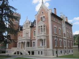 Vista lateral del Palacio de la Isla con fachada de ladrillo y detalles arquitectónicos góticos