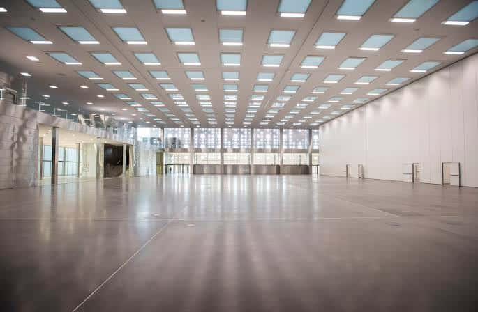 Interior del salón de exposiciones con suelo pulido y techo con iluminación integrada