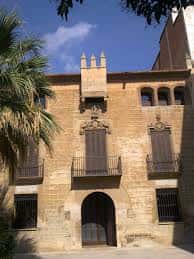 Fachada principal del Museo de L'Hospitalet con detalles arquitectónicos medievales y palmeras