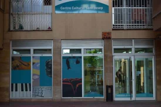 Entrada del centro cultural con carteles de actividades y letrero institucional