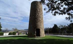Torre de piedra del Parque Torres con césped y árboles al fondo