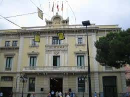 Fachada principal del edificio histórico de la plaza con banderas