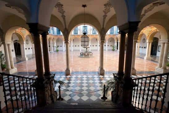 Patio interior del palacio con arcos, columnas y fuente central