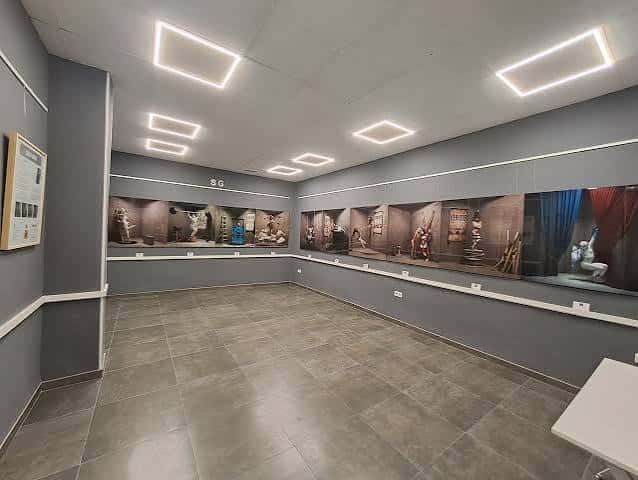 Sala de exposiciones con paneles fotográficos y suelo de baldosas