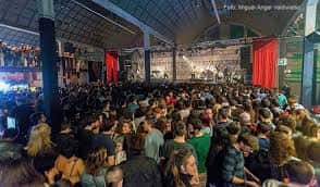 Interior del recinto con público asistiendo a un concierto bajo techo