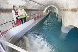 Pasarela de visita dentro del depósito con agua en movimiento