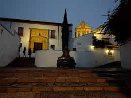 Vista nocturna de la Plaza de la Paz en Córdoba con escalinata y fachada iluminada