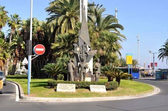 Monumento central rodeado de palmeras y zona peatonal