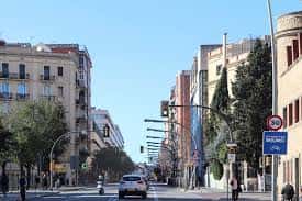 Vista diurna de la Carretera de Collblanc con edificios residenciales y tráfico ligero