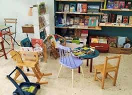Interior del café con zona infantil y estanterías de libros