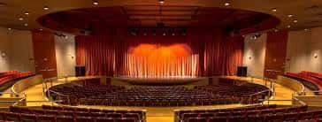Vista panorámica del auditorio principal con cortinas rojas y butacas