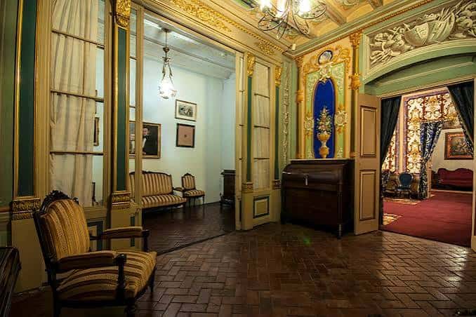 Salón interior del museo con decoración clásica, muebles antiguos y detalles dorados