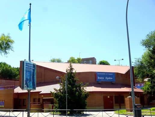 Vista exterior del Teatro Egaleo con la bandera ondeando en un día soleado