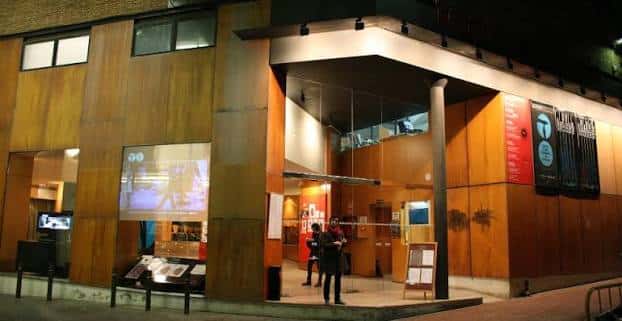 Vista nocturna de la fachada moderna del Teatre Alegria con iluminación cálida