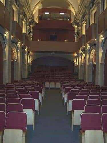 Interior del auditorio con butacas rojas y balcones ornamentados