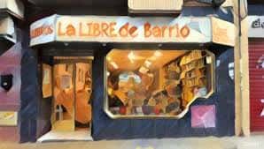 Fachada iluminada de La Libre de Barrio con escaparate visible