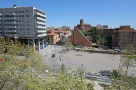 Vista panorámica del parque desde una altura con edificios al fondo