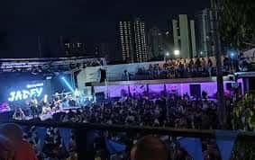 Concierto en vivo en la terraza de Penélope con escenario iluminado y multitud