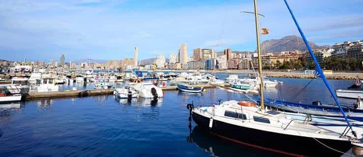 Vista panorámica del puerto deportivo de Benidorm con embarcaciones y skyline urbano al fondo