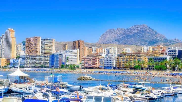Puerto de Benidorm con playa y montaña de fondo bajo cielo despejado