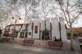Vista exterior del Centro Cultural Mercado de Getafe con fachada blanca y árboles en primer plano