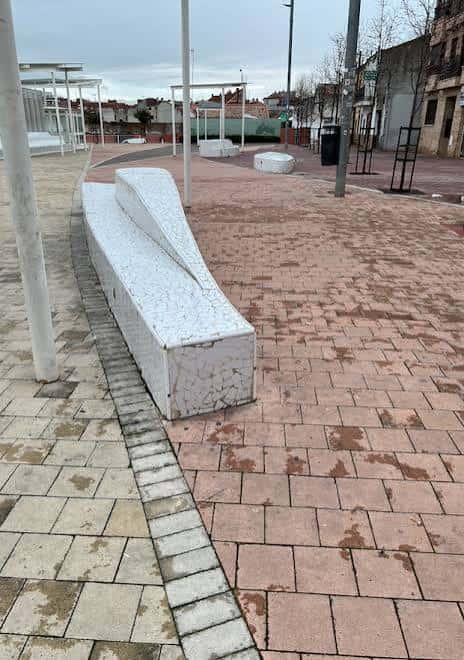 Área moderna de la plaza con bancos de piedra y pavimento de ladrillo