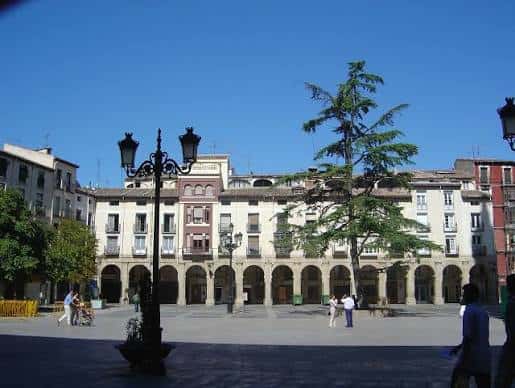 Vista panorámica de la Plaza del Mercado en Logroño con arcos y edificios históricos bajo un cielo azul