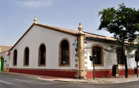 Fachada exterior del edificio en la calle, con detalles arquitectónicos y banderas