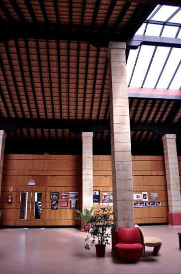 Vista del interior con mobiliario moderno, plantas y paneles informativos en las paredes