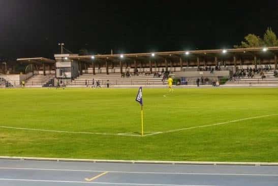 Estadio iluminado por la noche con espectadores en las gradas