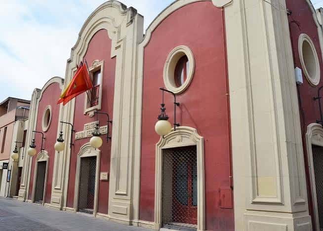 Fachada exterior del Teatro Salón Cervantes con bandera española y arquitectura neoclásica