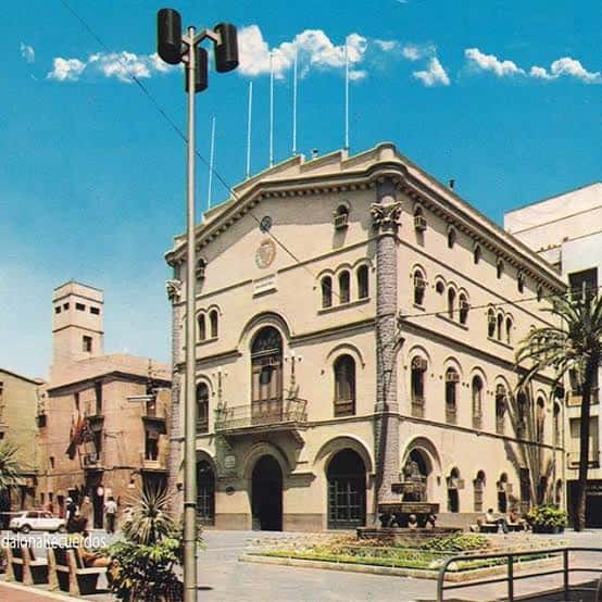 Plaza de la Vila con la fuente de los leones y el edificio del ayuntamiento bajo un cielo azul