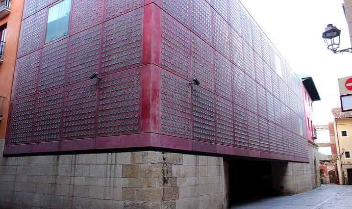 Detalle de la fachada moderna con paneles rojos y base histórica