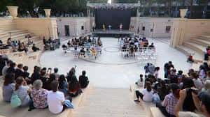 Evento cultural en el Anfiteatro Óscar Esplá con público sentado en las gradas