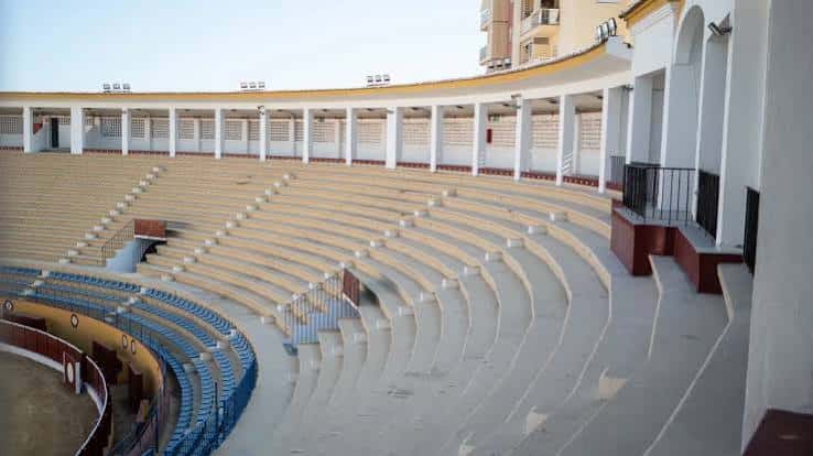 Interior de la plaza de toros mostrando las gradas vacías y el ruedo