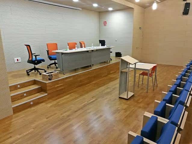 Escenario con mesa de panelistas y pupitres, configurado para eventos formales o mesas redondas