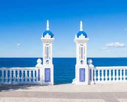 Detalle arquitectónico de los faros azules y blancos en la entrada de la playa