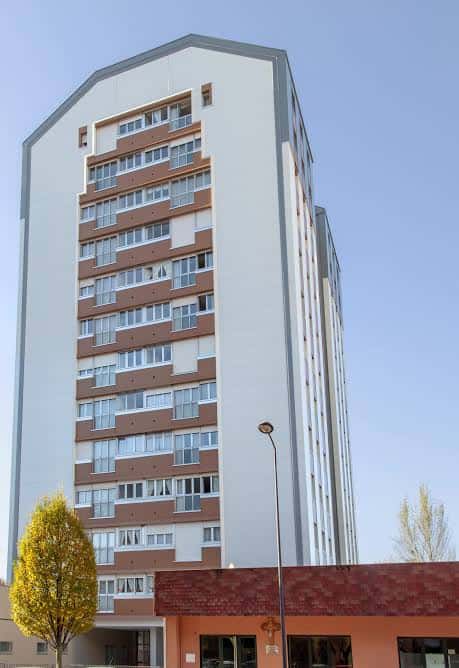 Fachada frontal de un edificio de viviendas en Puerto del Palo, Gijón, con diseño arquitectónico contemporáneo