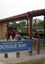 Vista del Centro de Educación Ambiental Bosquesur con personas reunidas bajo un porche
